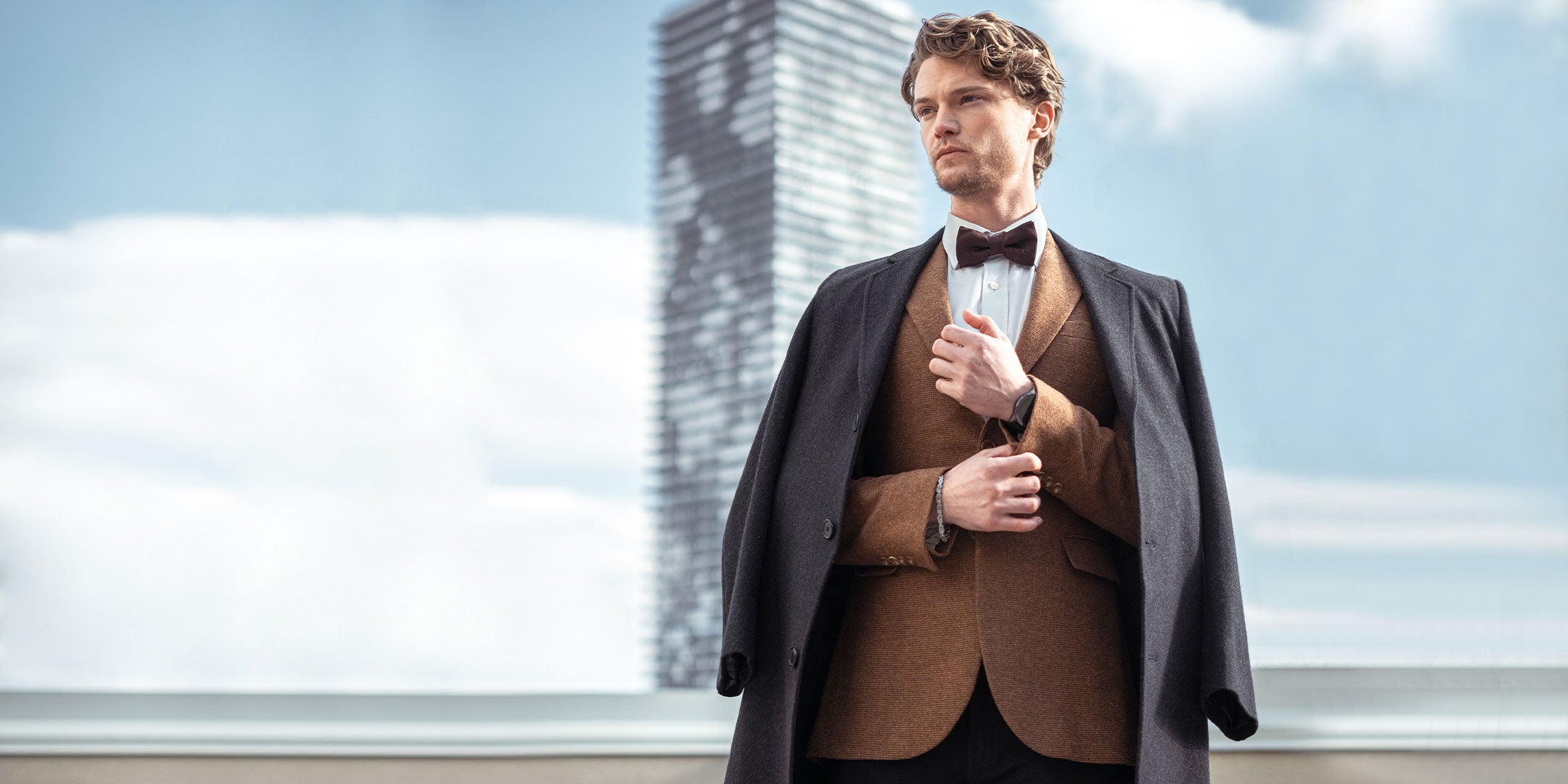 Close-up of a men's luxury formal wear collection featuring structured blazers with notch lapels, crisp white button-down shirts, and tailored chinos with leather belt details for the Zeitgeist winter edit