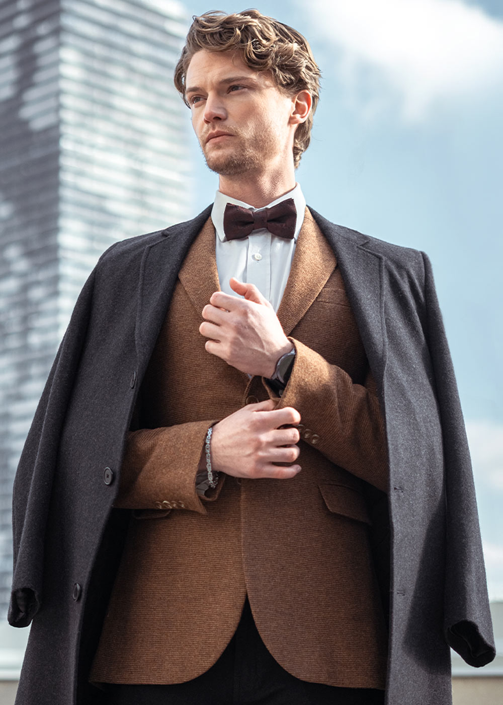 Close-up of a men's luxury formal wear collection featuring structured blazers with notch lapels, crisp white button-down shirts, and tailored chinos with leather belt details for the Zeitgeist winter edit