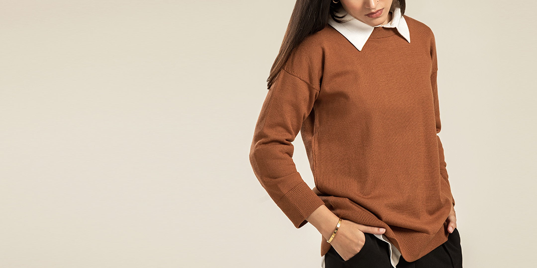 Women's winter knitwear by Cherie by Zeitgeist featuring a structured wool cape with a stand collar and a premium cable-knit sweater with ribbed cuffs.