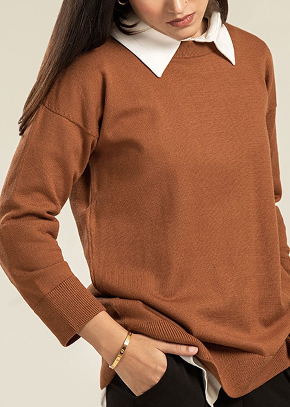 Women's winter knitwear by Cherie by Zeitgeist featuring a structured wool cape with a stand collar and a premium cable-knit sweater with ribbed cuffs